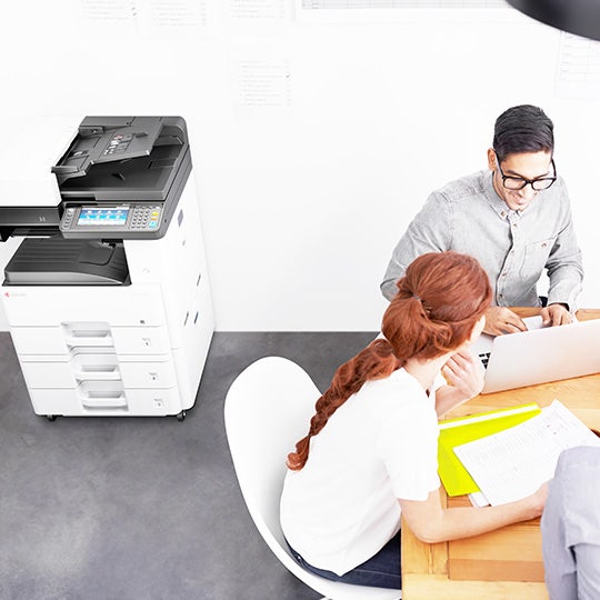 pohled shora na kolegy sedící v kanceláři vedle MFP Kyocera