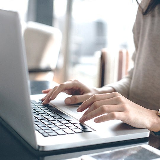 hands typing in a laptop