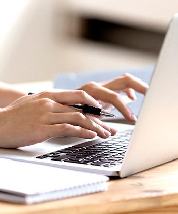 ruce píšící na laptopu