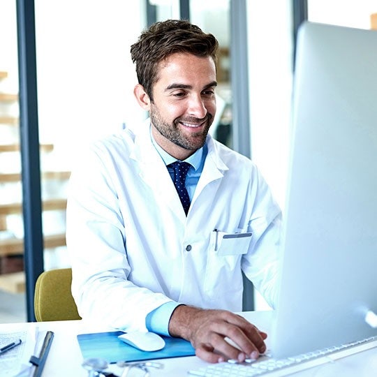 doktor pracující za stolním počítačem