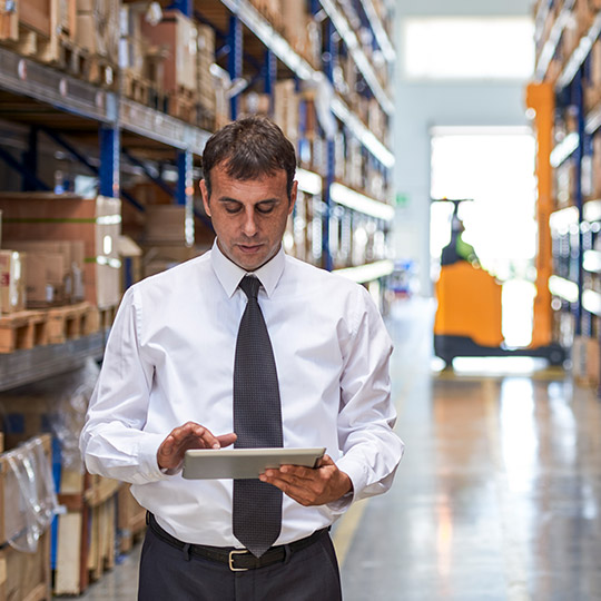 muž pracující na tabletu ve skladu