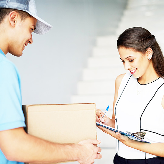 žena přebírá zásilku od kurýra