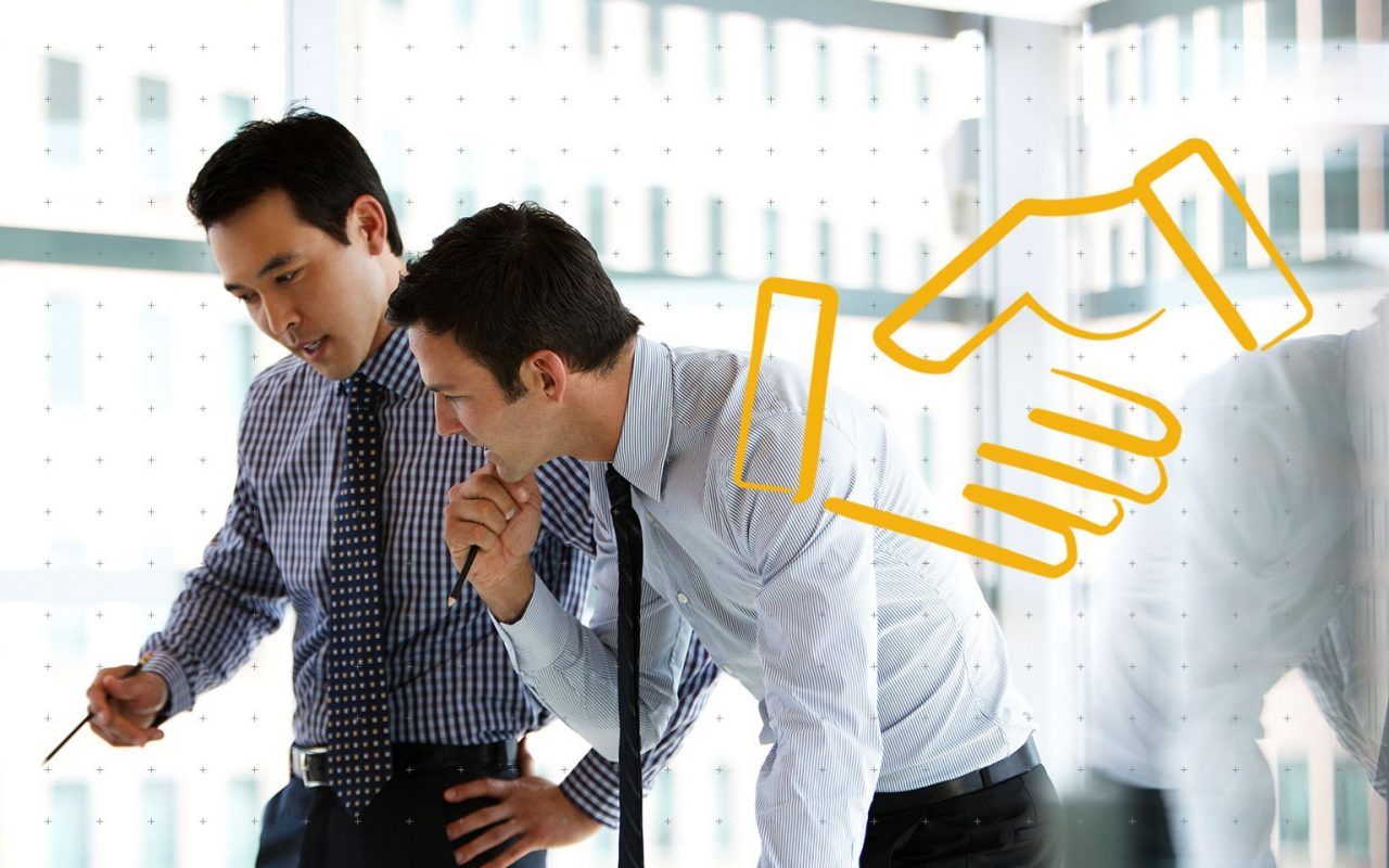 detail na dva kolegy v práci a gesto potřásajících rukou