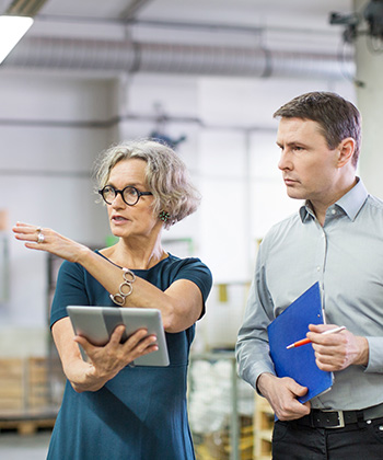 žena něco ukazuje kolegovi ve skladu