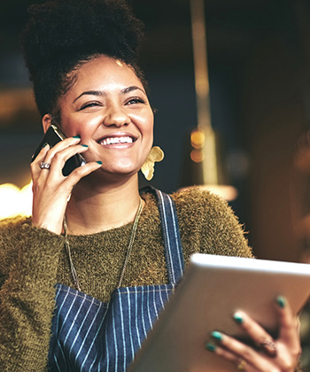 číšnice telefonuje a drží tablet
