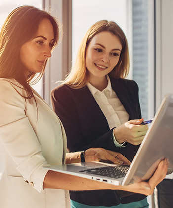 dvě kolegyně pracující za laptopem