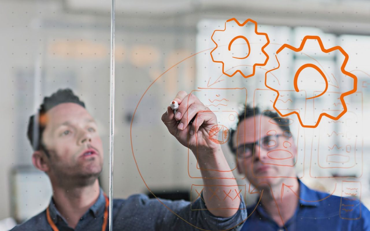 kolega kreslí na sklo diagram pro dalšího kolegu