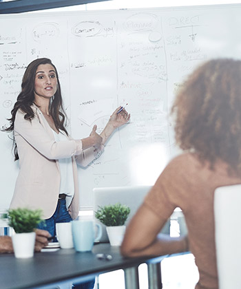 žena prezentuje na meetingu u tabule