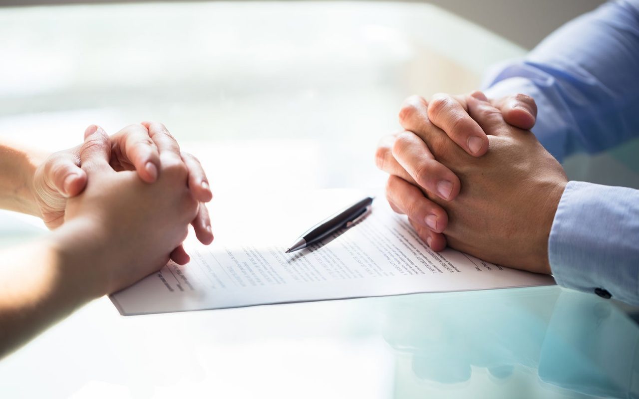 propletené prsty na stole