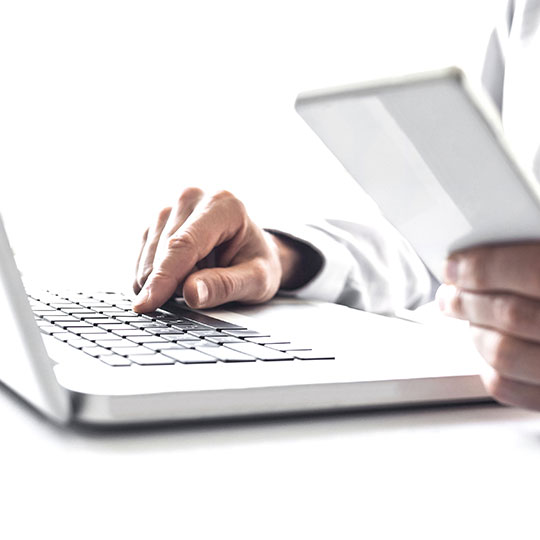 detail na ruce píšící na klávesnici notebooku