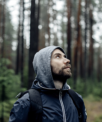 muž v lese se dívá nahoru