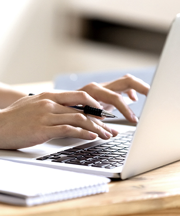 ruce píšící na laptopu