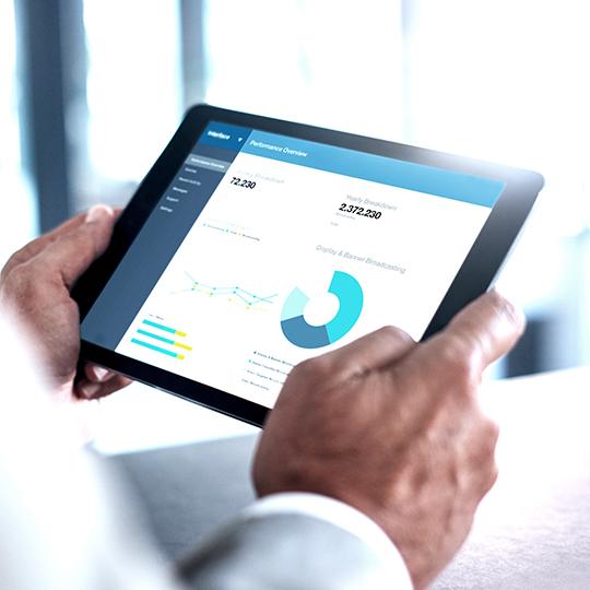 close up of man holding a tablet with a graph on the screen