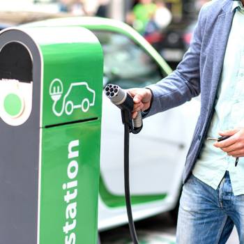 man charging car at charging point